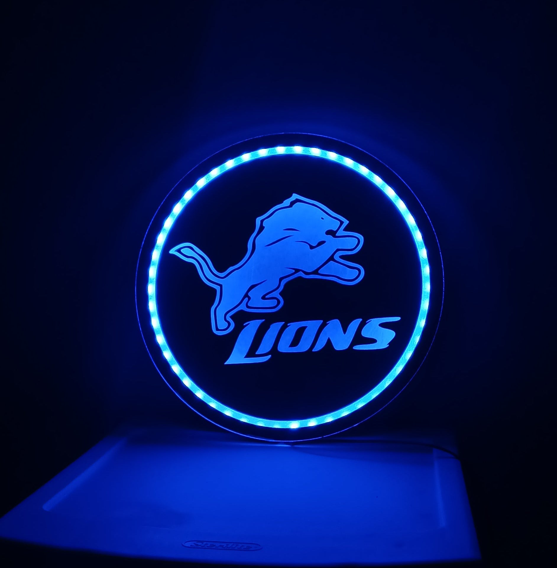 Blue neon sign with a logo on a dark background